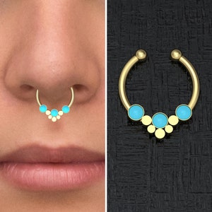 May include: Gold nose ring with a turquoise stone cluster. The ring is a hoop with a decorative cluster of turquoise stones in the center.