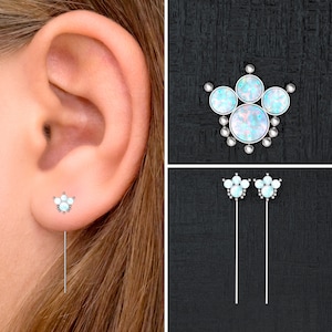 Puede incluir: Un par de pendientes de plata con un racimo de piedras de ópalo en forma de flor. Los pendientes se muestran en la oreja de una modelo.