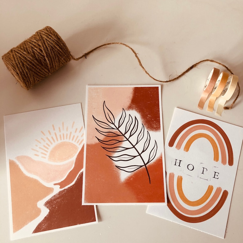 May include: Three printable art prints with a minimalist design featuring abstract shapes and patterns in shades of brown, peach, and white. The prints include a sun, a leaf, and a rainbow with the word "HOPE" in the center.