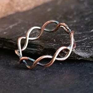 May include: A silver and copper wire ring with a twisted design.