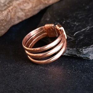 May include: A rose gold ring with three bands. The ring is made of metal and has a smooth finish.