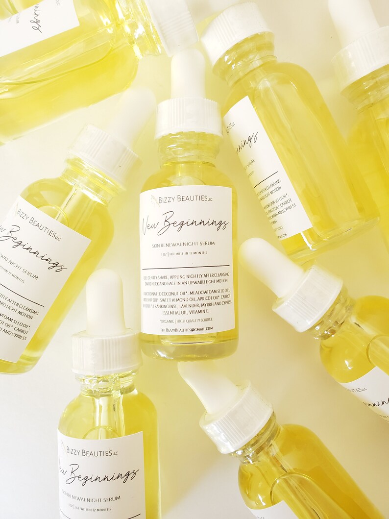 May include: Multiple glass bottles of yellow serum with white dropper tops and labels that read "Bizzy Beauties, Inc. New Beginnings Skin Renewal Night Serum See Results Within 12 Months".