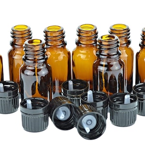 May include: A group of ten amber glass bottles with black dropper caps. The bottles are arranged in a semi-circle with the caps facing outward. The bottles are all the same size and shape.