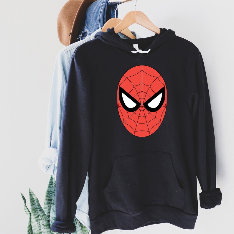 May include: Black hooded sweatshirt featuring a red and black Spider-Man mask design on the front. The graphic includes a red web pattern and white eye shapes. The sweatshirt has a front pocket and a drawstring hood.
