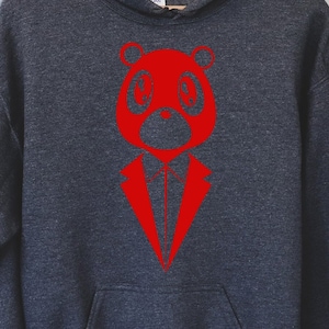 May include: A dark gray hoodie featuring a red graphic of a bear wearing a suit. The bear has large, round eyes and a stylized suit design. The hoodie has a front pocket and a hood with a drawstring.