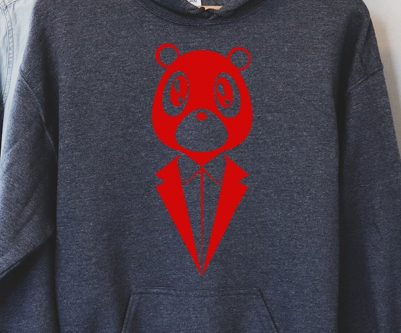 May include: A dark gray hoodie featuring a red graphic of a bear wearing a suit. The bear has large, round eyes and a stylized suit design. The hoodie has a front pocket and a hood with a drawstring.