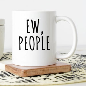 Pu&ograve; includere: Tazza da caff&egrave; in ceramica bianca con testo nero che recita "EW, PEOPLE".