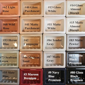May include: A grid of small, rectangular ceramic soap dishes in various colors, including light rose, white, and navy blue. Each dish is labeled with a number and color name, such as "#62 Light Rose" and "#9 Navy Blue Premium."