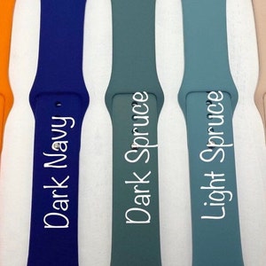May include: Five different colored silicone watch bands. The bands are labeled "Fall Orange", "Dark Navy", "Dark Spruce", "Light Spruce", and "Blush Pink".
