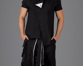 Puede incluir: Camisa negra de lino de manga corta con cierre de botones asimétrico y pantalón corto a juego. Los pantalones presentan ribetes blancos y correas decorativas. Zapatillas blancas completan el conjunto. Un conjunto moderno y elegante.