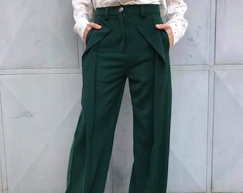 May include: A pair of wide-leg, dark green pants with a high waist and a center front seam. The pants have a slightly flared leg and are made of a smooth, wrinkle-resistant fabric.