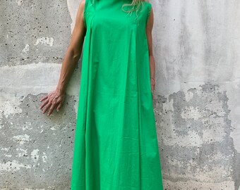 May include: A sleeveless maxi dress in a bright green color. The dress has a high neckline and a simple, flowing silhouette.