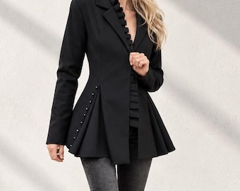 May include: A black blazer with a ruffled collar, long sleeves, and a flared peplum waist featuring a row of small buttons along the side. The blazer is paired with dark grey flared denim jeans and pointed black shoes, creating a structured look.