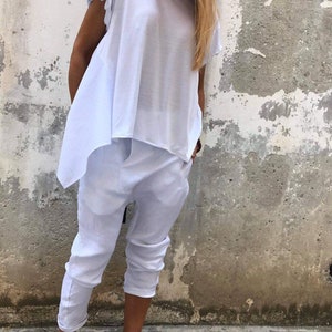 Puede incluir: Una blusa blanca holgada y asim&eacute;trica con mangas cortas y un pantal&oacute;n blanco corto. El conjunto est&aacute; hecho de una tela suave y ligera.