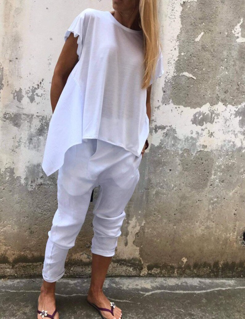 Puede incluir: Una blusa blanca holgada y asim&eacute;trica con mangas cortas y un pantal&oacute;n blanco corto. El conjunto est&aacute; hecho de una tela suave y ligera.