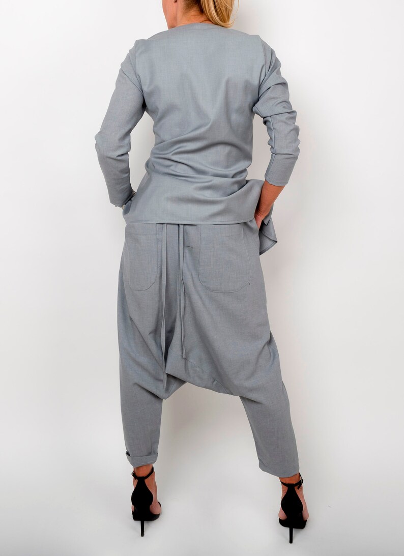 May include: A gray, long-sleeved shirt and matching pants with a loose, flowing fit. The pants have a unique design with a gathered crotch and a drawstring.