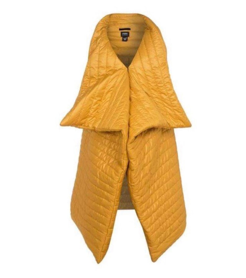 May include: Mustard yellow quilted scarf with a unique design. The scarf has a wide collar that tapers down into two long panels. The fabric has a subtle sheen and a diamond-shaped quilted pattern. The scarf is a fashion accessory.