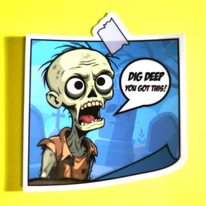 Op de afbeelding: Een cartoonsticker met een zombie met een open mond en grote ogen. De zombie draagt een bruin shirt en staat tegen een blauwe achtergrond met een kerkhofscène. Tekst in een tekstballon luidt "DIG DEEP YOU GOT THIS!"