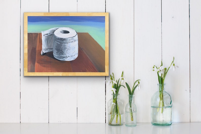 May include: A painting of a white toilet paper roll on a wooden table with a blue and green background.