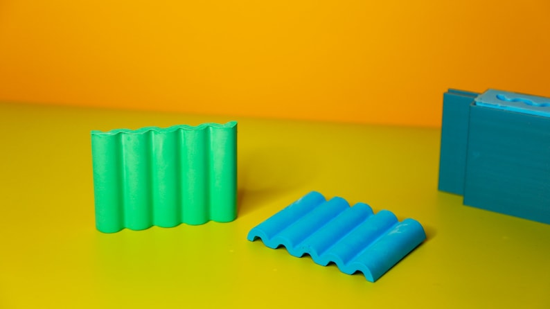 Puede incluir: Dos juegos de bloques de construcci&oacute;n de pl&aacute;stico de colores. Un juego es verde y el otro es azul. Los bloques tienen forma de techo ondulado.