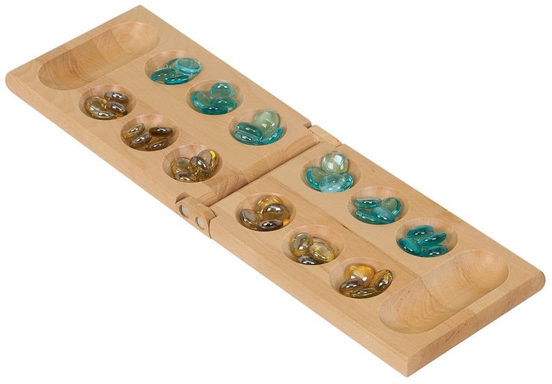 May include: A wooden Mancala board game with two rows of six pits, each containing glass marbles. The pits are filled with blue and yellow marbles.