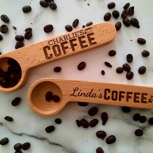 May include: Two wooden coffee scoops with engraved text. The top scoop says "Charlie's Coffee" and the bottom scoop says "Linda's Coffee". Both scoops have a small coffee cup icon engraved on them.