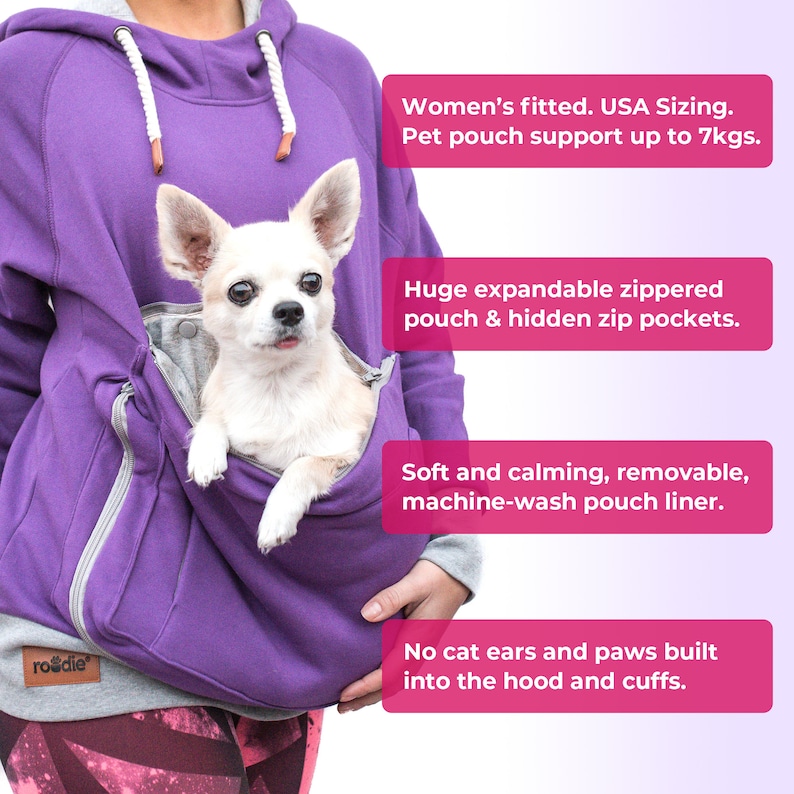 May include: Purple hoodie with a built-in pet pouch and a small white dog inside. The hoodie has a zippered pouch and hidden pockets. The text "Women's fitted. USA Sizing. Pet pouch support up to 7kgs." is visible in the image. The text "Huge expandable zippered pouch & hidden zip pockets." is visible in the image. The text "Soft and calming, removable, machine-wash pouch liner." is visible in the image. The text "No cat ears and paws built into the hood and cuffs." is visible in the image.