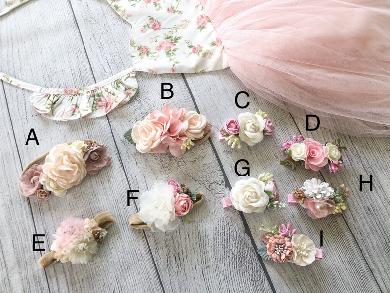 May include: Nine floral hair accessories with different styles and colors. The accessories are arranged on a light wood surface. The accessories are labeled with letters A through I.