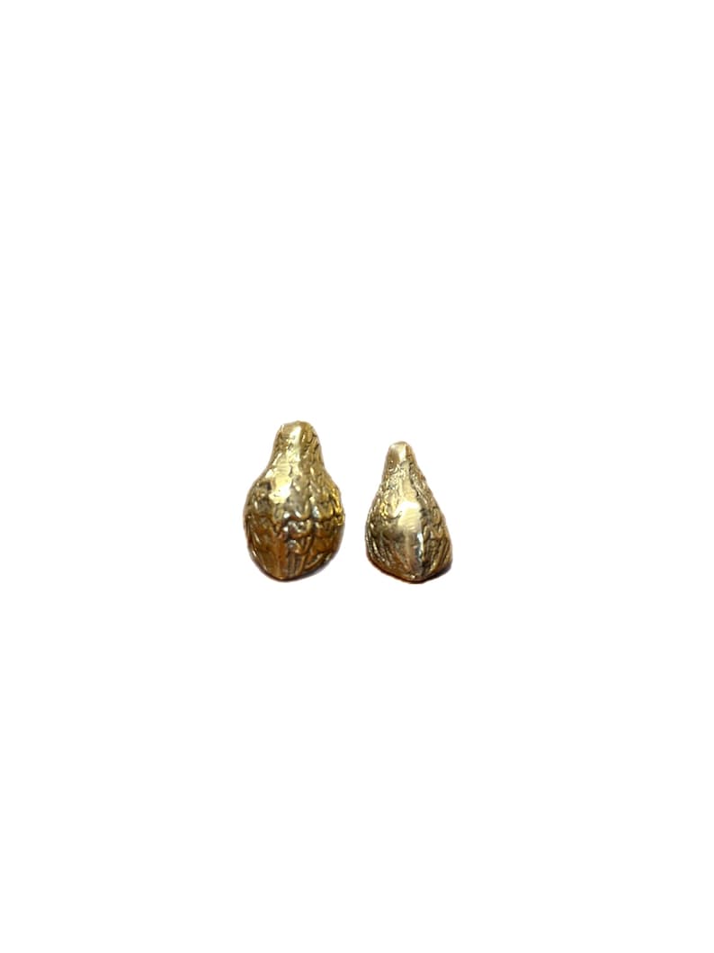 May include: Two gold-colored, pear-shaped decorative objects. The objects have a textured surface with a detailed, organic pattern. The objects are displayed against a white background.