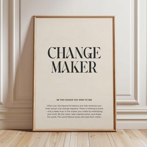Puede incluir: Un póster motivacional con fondo beige y texto negro. El texto dice "CHANGE MAKER" en letras grandes en la parte superior y "BE THE CHANGE YOU WISH TO SEE" en letras más pequeñas debajo. El texto continúa con una cita sobre la importancia de abrazar el poder interior y marcar la diferencia en el mundo.