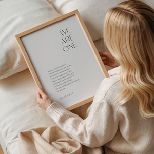 May include: A framed print with a white background and black text. The text reads "WE ARE ONE" and includes a poem about honoring the soul and the universe within. The text ends with "NAMASTE".