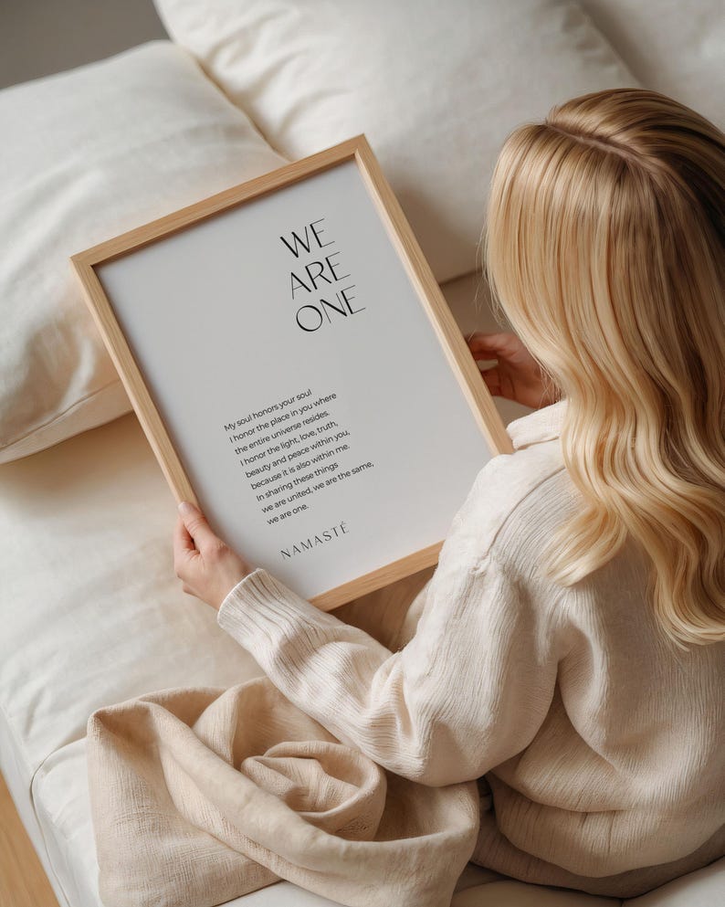 May include: A framed print with a white background and black text. The text reads "WE ARE ONE" and includes a poem about honoring the soul and the universe within. The text ends with "NAMASTE".