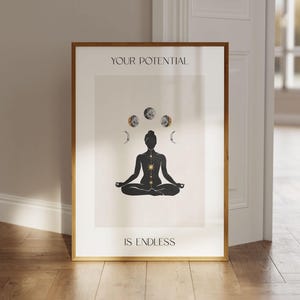 Könnte beinhalten: Ein gerahmter Druck mit einer schwarzen Silhouette einer Person, die in einer Yoga-Pose sitzt, mit einem goldenen Stern in der Mitte ihrer Brust. Der Druck enthält den Text "YOUR POTENTIAL IS ENDLESS" und eine Reihe von Monden und Sternen über der Person.