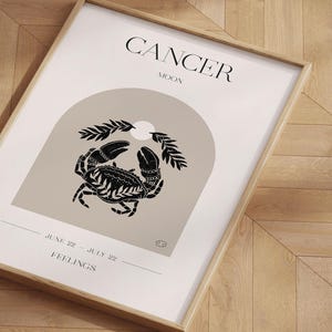 May include: A minimalist poster with a black and white illustration of a crab, the word "CANCER" in black text, and the words "MOON" and "FEELINGS" in smaller black text. The poster also includes the dates "JUNE 22 - JULY 22" and the astrological symbol for Cancer.