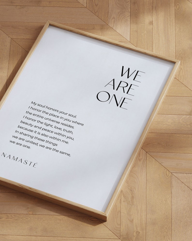 May include: A framed print with a white background and black text. The text reads "WE ARE ONE" in large letters at the top of the print. Below the large text is a poem that reads "My soul honors your soul. I honor the place in you where the entire universe resides. I honor the light, love, truth, beauty and peace within you, because it is also within me. In sharing these things we are united, we are the same, we are one. NAMAST&Eacute;"