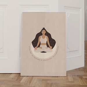 May include: A beige poster with a woman meditating in a lotus pose. She is surrounded by a dark circle with white stars. The text on the poster reads "Attached to nothing & connected to everything."