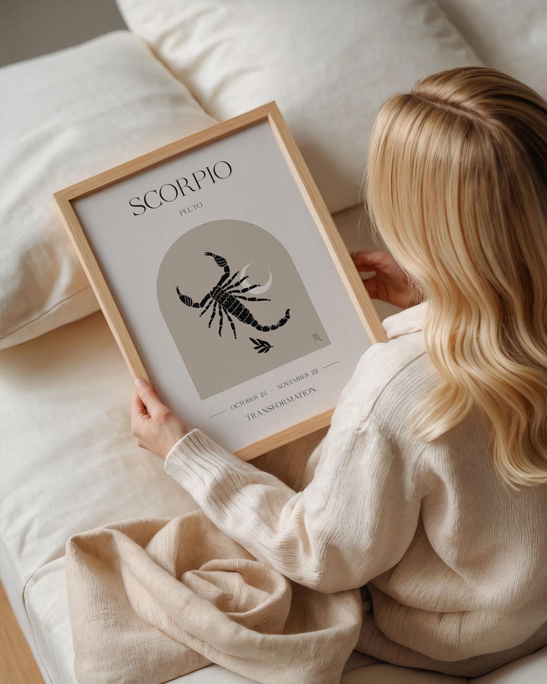 Puede incluir: Una impresi&oacute;n enmarcada con un dise&ntilde;o minimalista que presenta el signo del zod&iacute;aco Escorpio. La impresi&oacute;n est&aacute; en un marco de madera claro y tiene un fondo beige con una ilustraci&oacute;n de escorpi&oacute;n negro. El texto "Scorpio" y "Pluto" est&aacute;n impresos en negro en la parte superior de la impresi&oacute;n. Las fechas "October 23 - November 22" y la palabra "Transformation" est&aacute;n impresas en la parte inferior de la impresi&oacute;n.