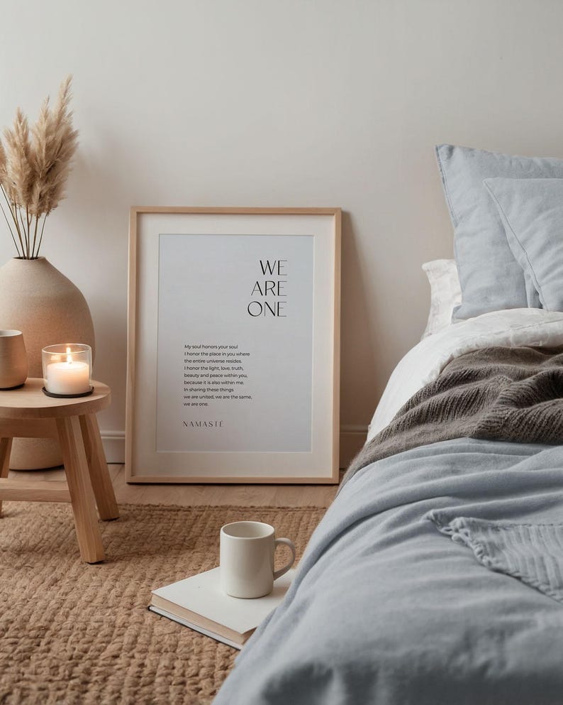 May include: A framed print with the text "WE ARE ONE" and a poem about the soul and the universe. The print is hanging on a wall in a bedroom with a bed and a rug.