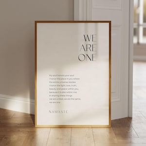 May include: A framed print with a minimalist design featuring the text "WE ARE ONE" in black lettering. The print includes a quote about honoring the soul and the universe, ending with the word "NAMASTE".