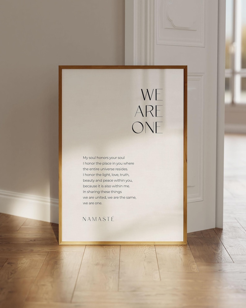 May include: A framed print with a minimalist design featuring the text "WE ARE ONE" in black lettering. The print includes a quote about honoring the soul and the universe, ending with the word "NAMASTE".
