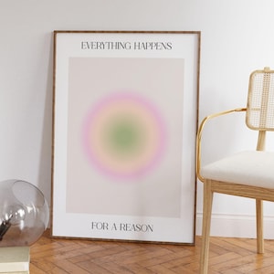 May include: A framed print with a light pink, green, and yellow gradient circle in the center. The text "EVERYTHING HAPPENS FOR A REASON" is printed in black at the top and bottom of the print.