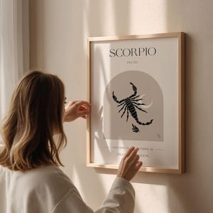 Puede incluir: Un p&oacute;ster minimalista con un fondo beige que presenta una ilustraci&oacute;n de escorpi&oacute;n negro y el texto "SCORPIO" y "PLUTO". El p&oacute;ster tambi&eacute;n incluye las fechas "OCTOBER 23 - NOVEMBER 22" y el s&iacute;mbolo del signo zodiacal Escorpio.