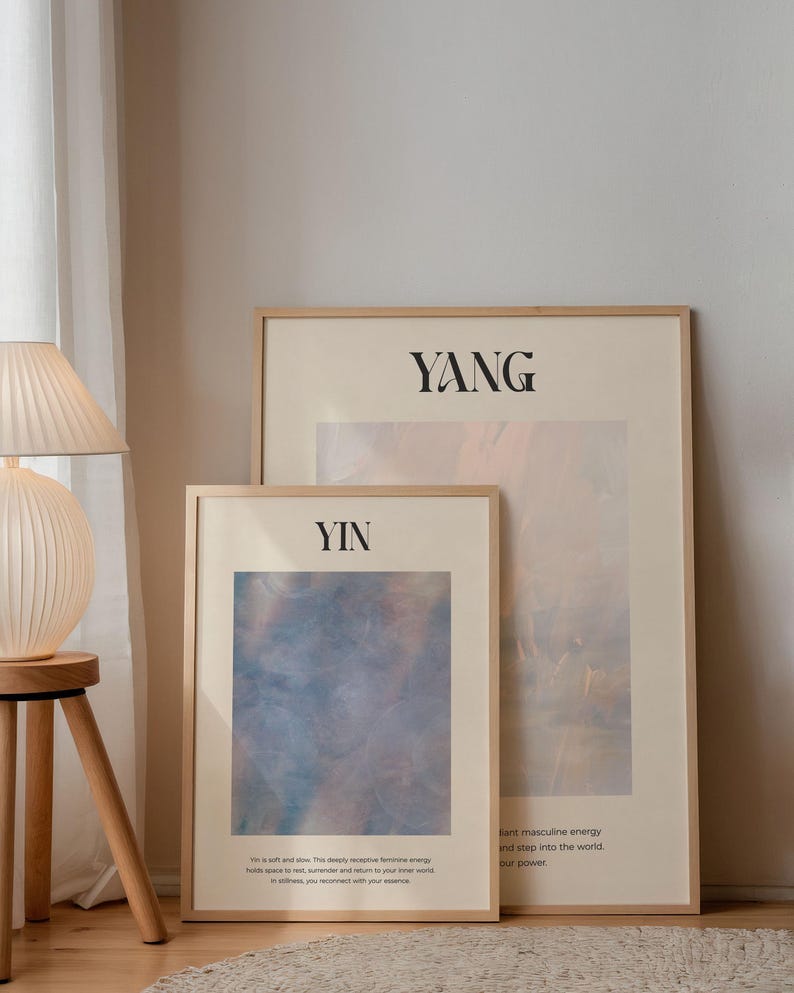 Op de afbeelding: Twee ingelijste kunstdrukken met de woorden "Yin" en "Yang" in zwarte tekst. De "Yin" print heeft een blauw en roze abstract ontwerp. De "Yang" print heeft een beige en roze abstract ontwerp. Beide zijn in lichte houten frames.