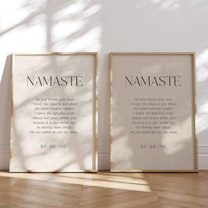 K&ouml;nnte beinhalten: Zwei gerahmte Drucke mit dem Wort "NAMAST&Eacute;" oben, gefolgt von einem Gedicht. Die Drucke haben einen beigefarbenen Hintergrund und einen hellbraunen Rahmen. Der Text ist in einer dunklen, eleganten Schriftart gehalten. Der untere Teil des Drucks lautet "WE ARE ONE."