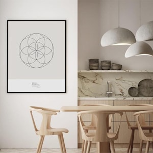 May include: A black framed print with a geometric design in a white room with a wooden dining table and chairs. Three gray pendant lights hang above the table.