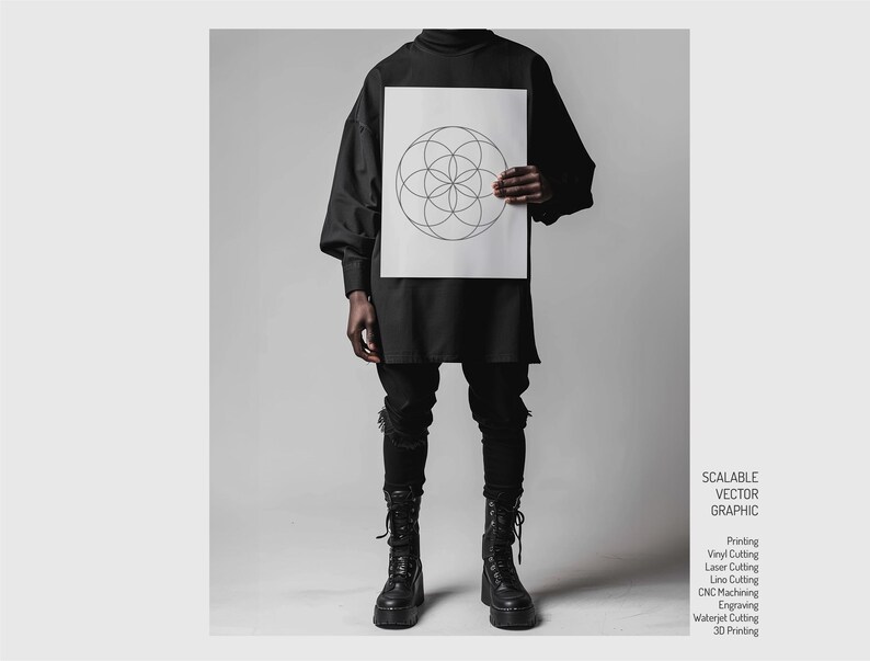 May include: A black and white geometric design on a white sheet of paper. The design is a circle with overlapping circles inside. The paper is being held by a person wearing a black shirt and black pants.