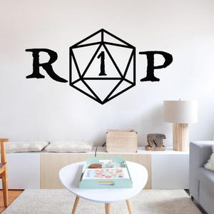May include: A black and white wall decal with the letters "R" and "P" on either side of a black and white illustration of a twenty-sided die with the number "1" on it.