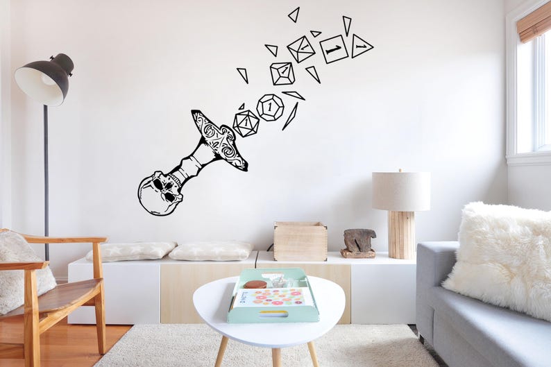 May include: Black and white wall decal of a skull with a sword piercing through it. The sword is breaking apart into dice with different numbers on them.
