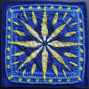 May include: A crocheted square with a blue and yellow starburst pattern. The center of the starburst is white.