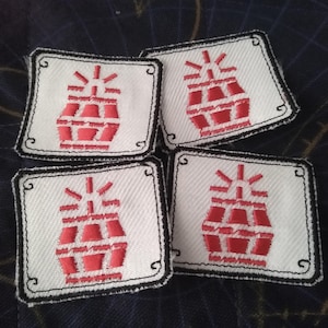 May include: Four white fabric patches with black stitching and a red embroidered grenade design.